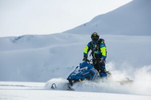 Decoratieve afbeelding van een sneeuwscooter in de sneeuw.